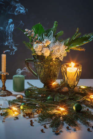 christmas still life with branch of fir, candles and lightsの写真素材