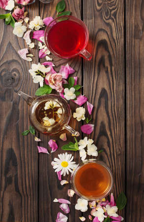 various teas with herbs and flowers on a dark wooden table, top viewの写真素材