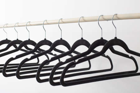 gray empty hangers on railing white backgroundの写真素材