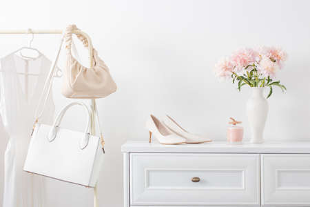 white dresser with clothes and flowers in white roomの写真素材
