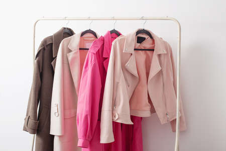 female autumn clothes on hangers in white roomの写真素材
