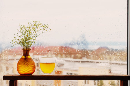 hot tea in thermo glass on background window with raindropsの写真素材