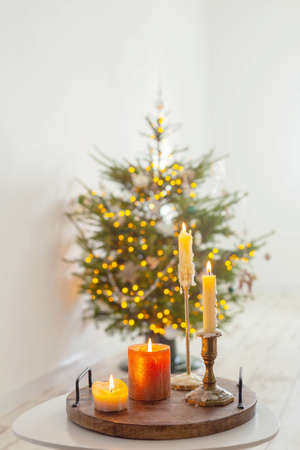 burning candles on table on background christmas tree at homeの写真素材