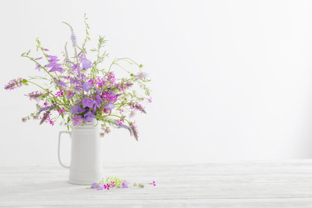 summer wild flowers in white jug on white backgroundの写真素材