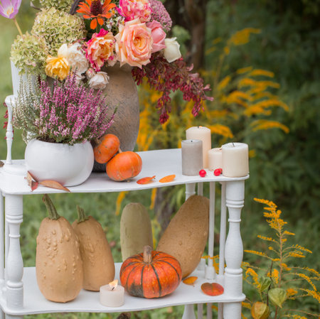 beautiful autumn decor with flowers, berries, pumpkins in gardenの写真素材