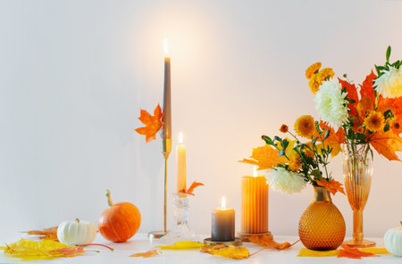 beautiful autumn home decor with burning candles in white interiorの写真素材