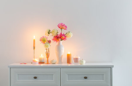 beautiful decor with flowers, pumpkins, candles on white backgroundの写真素材