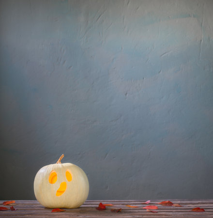 halloween pumpkin on wooden table on dark blue backgroundの写真素材