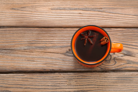 orange cup of coffee with spices on wooden backgroundの写真素材