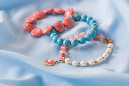 bracelets made of natural stones on blue silk fabricの写真素材