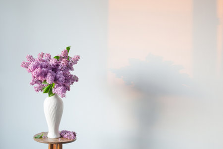 lilac flowers in white vase on background white wallの写真素材