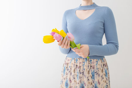 young girl with bouquet of tulips on white backgroundの写真素材