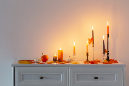 beautiful autumn home decor with burning candles in white interiorの写真素材