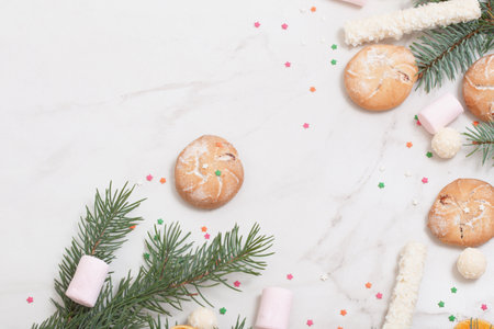 candies and cookies with christmas tree branches on white marble backgroundの写真素材