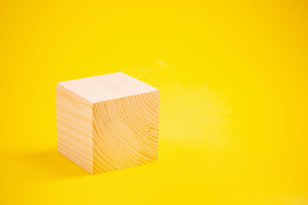wooden podium cube on bright yellow backgroundの写真素材