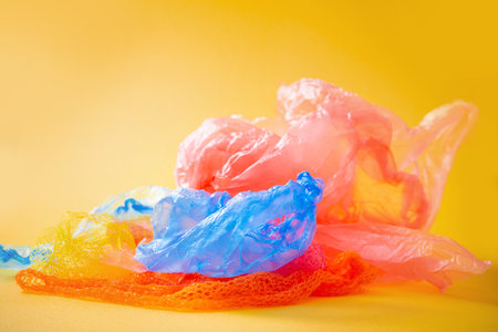 plastic trash on bright yellow backgroundの写真素材