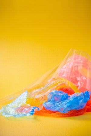 plastic trash on bright yellow backgroundの写真素材
