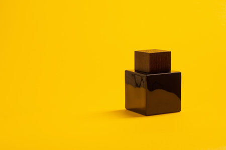 black perfume bottle on yellow backgroundの写真素材
