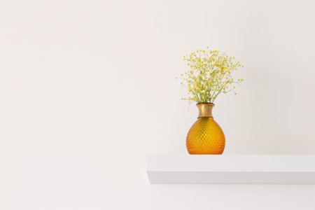 yellow gypsophila in glass vase in white roomの写真素材