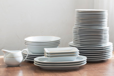 various cutlery on a wooden table against a white wallの写真素材