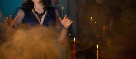 young beautiful woman in golden mask and blue vintage dress in dark roomの写真素材