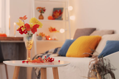 beautiful autumnal bouquet with flowers and leaves at homeの写真素材