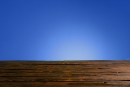 dark woodewn table on background bright blue wallの写真素材