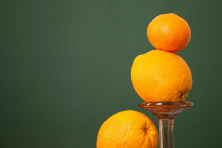 oranges with vintage glass vase on green backgroundの写真素材