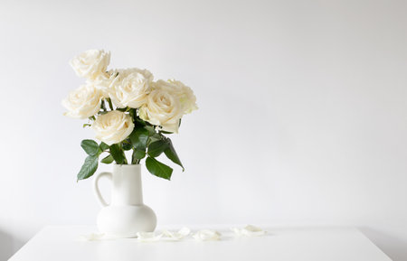 bouquet of white roses in jug on white backgroundの写真素材