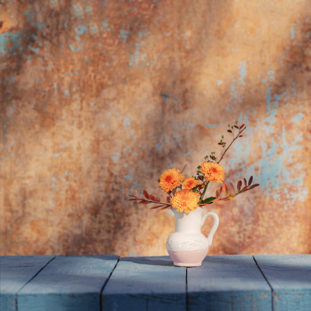 chrysanthemum flowers in jug on background old wall in sunlightの写真素材