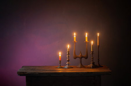 burning candles in vintage candlesticks on dark backgroundの写真素材