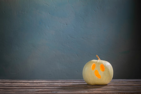 halloween pumpkin on wooden table on dark blue backgroundの写真素材