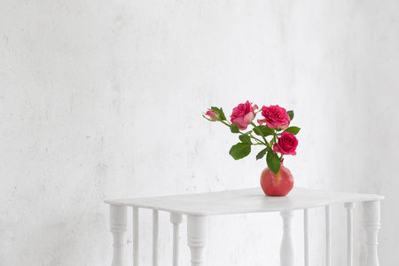 pink roses in pink vase on background old white wallの写真素材