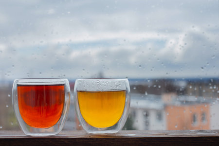 hot tea in thermo glass on background window with raindrops