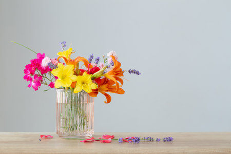 summer flowers in glass vase on wooden shelfの写真素材
