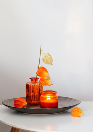 autumnal still life with flowers and candles, on white tableの写真素材