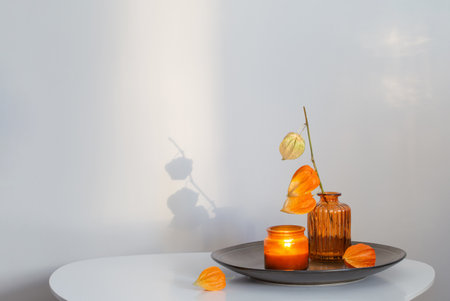 autumnal still life with flowers and candles, on white tableの写真素材