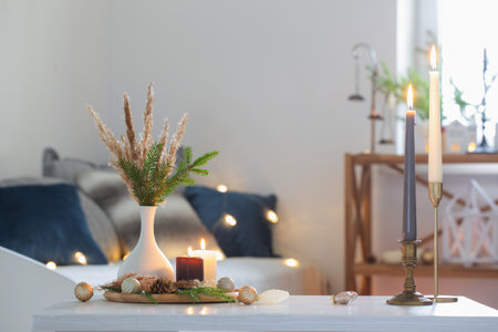 burning candles with christmas decor in white cozy interiorの写真素材