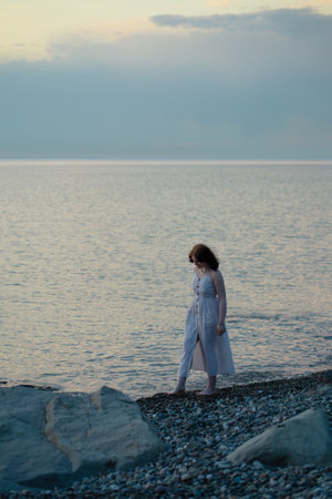 young girl by sea at sunsetの写真素材