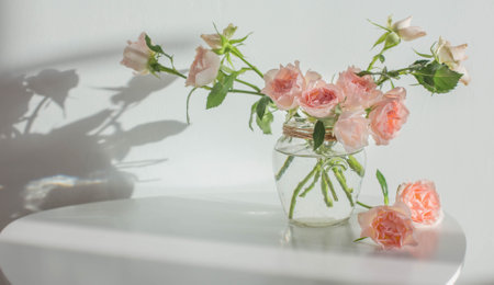 pink roses in glass jar on white modern table on background white wallの写真素材