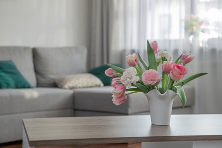 pink spring flowers in white ceramic vase in modern home interiorの写真素材