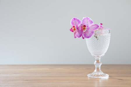 purple orchid in glass on wooden tableの写真素材