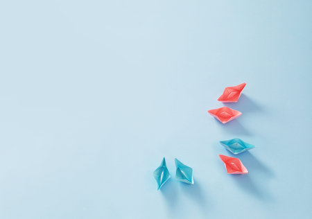 pink and blue paper boats on blue background, concept of various relationships