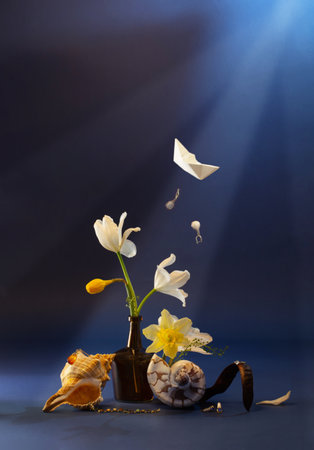 still life witn sinking treasure ship, flowers, seashell on dark blue backgroundの写真素材