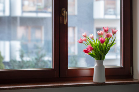 pink tulips in vase on windowsillの写真素材