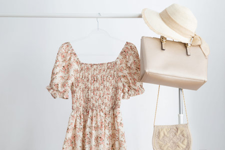 summer dress with hat and handbags on hanger on white backgroundの写真素材