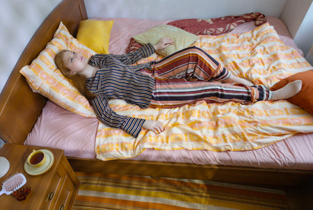 teenager girl in bed at homeの写真素材