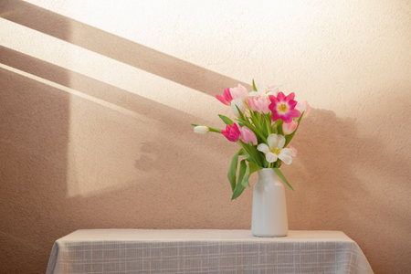 tulips in vase on table on background wallの写真素材