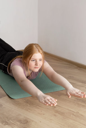 young woman doing physical exercises on the floor at home