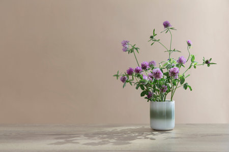 still life with clover in ceramic cup on wooden table